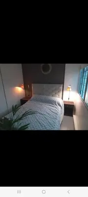 a bedroom with a bed and a lamp and a window at Derpa Zion in Cordoba