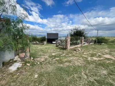 a fence in a field with a building in the background at El Descanso in San Roque