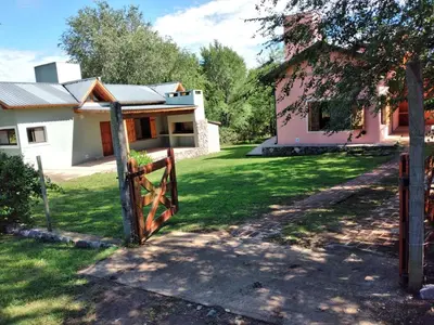 a house with a gate in front of a yard at Complejo Aguas Calmas - Casa Remanso in Los Reartes