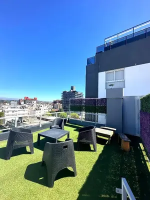 a patio with chairs and tables on top of a building at Depto Nuevo en el Centro, Cochera, Pile, Aire Ac in Villa Carlos Paz