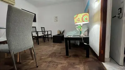 a room with a table with a lamp and a chair at CENTRO Departamento dos dormitorios in Cordoba