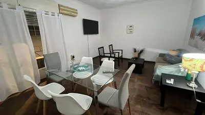 a living room with a glass table and white chairs at CENTRO Departamento dos dormitorios in Cordoba