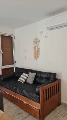 a black leather couch in a room with a window at Brisas Rumipal Dúplex Premium in Villa Rumipal