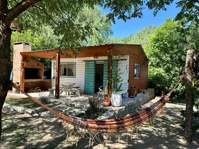 a hammock in front of a log cabin at Cabañas Enki in La Paz