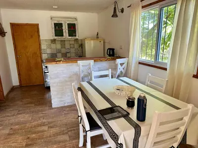 a kitchen with a table and chairs in a room at Cabañas Enki in La Ramada