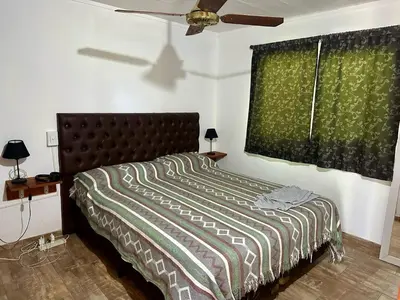 a bedroom with a bed and a ceiling fan at Cabañas Enki in La Ramada