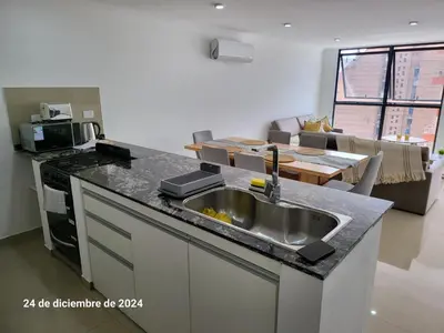 a kitchen with a sink and a living room at plazaColon in Cordoba