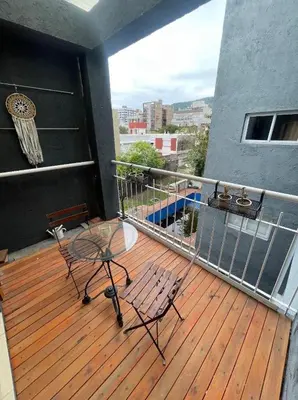 a deck with a table and chairs on a balcony at Finlay Departamento in Villa Carlos Paz