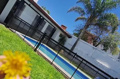 a house with a fence next to a swimming pool at Departamentos Luluara in Villa Carlos Paz