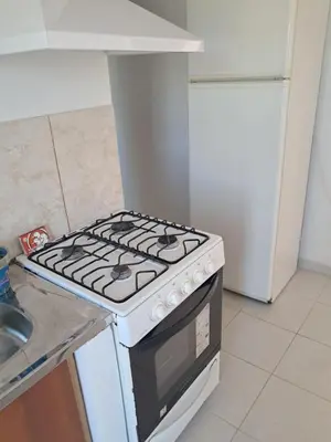 a stove top oven in a kitchen next to a sink at Departamento para 2 personas in Alta Gracia