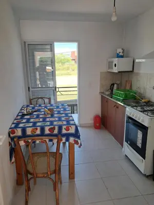 a kitchen with a table with chairs and a stove at Departamento para 2 personas in Alta Gracia