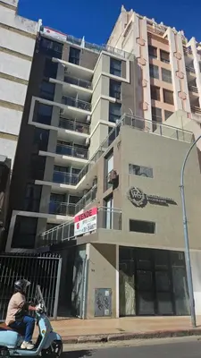 a man riding a scooter in front of a building at Duplex Luxor Calazans in Cordoba