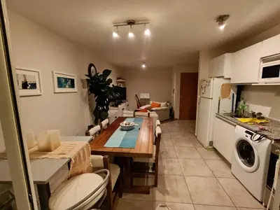 a kitchen and living room with a table and a refrigerator at Luminous department for 2 Ubicado a 10 cuadras de Shopping Nuevocentro in Cordoba