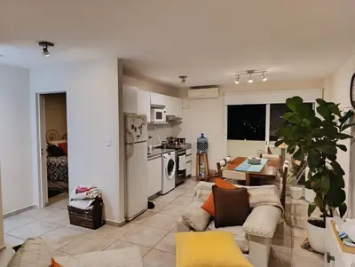 a living room with a couch and a kitchen at Luminous department for 2 Ubicado a 10 cuadras de Shopping Nuevocentro in Cordoba