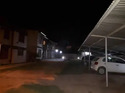 a white car parked in a parking lot at night at Luma Departamento, con Pileta in Villa Dolores