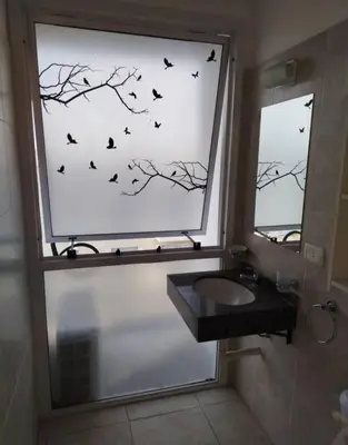 a bathroom with a window with birds on the wall at Departamento 1 dormitorio in Cordoba