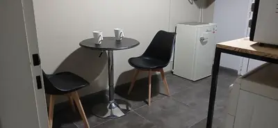 a small table with two chairs and a small refrigerator at alecayluna in Berrotarán
