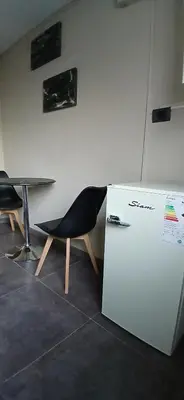 a chair sitting next to a table and a refrigerator at alecayluna in Berrotarán