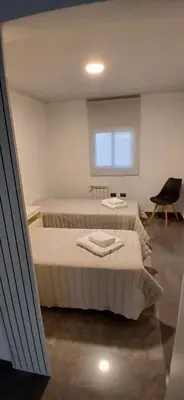 a bedroom with two beds and a chair at aleyluna in Berrotarán