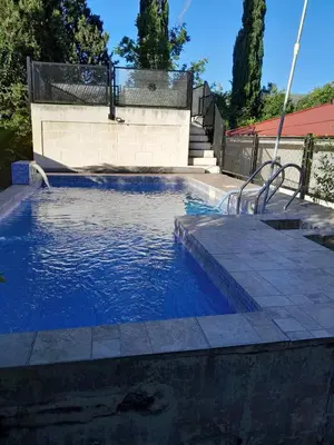 a swimming pool with a bench in the water at Casa ideal Pileta, Quincho y Patio Enorme in Bialet Massé