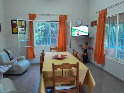 a living room with a table and a tv at Casa ideal Pileta, Quincho y Patio Enorme in Bialet Massé