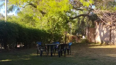 a table and chairs in the shade of a tree at Acogedora cabaña en el corazón de Nono in Nono