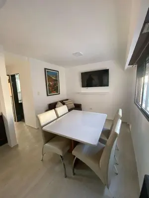 a dining room with a white table and chairs at Departamento cómodo en Cordoba Capital in Cordoba