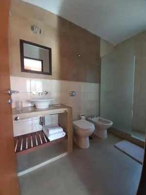 a bathroom with a sink and a toilet and a mirror at CuyenCo in Santa Rosa de Calamuchita