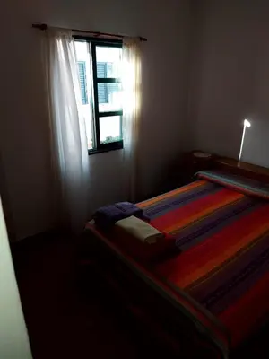 a bedroom with a striped bed with a window at Castillo Del Lago - Carlos Paz - D19 in Villa Carlos Paz