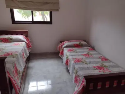 two twin beds in a room with a window at Portal del rio in Mina Clavero