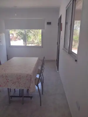 a room with a table and chairs and a window at Portal del rio in Mina Clavero