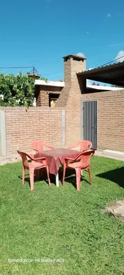a group of red picnic tables in the grass at Dpto Marina in Villa Cura Brochero