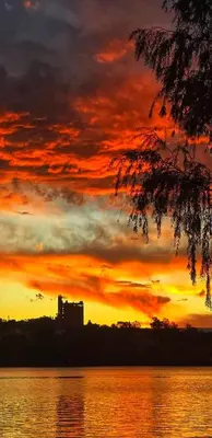 a sunset over a body of water with a building at Cómoda y Espaciosa Casa Céntrica Frente al Lago San Roque - Carlos Paz in Villa Carlos Paz