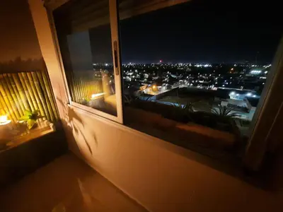 a window with a view of a city at night at Terra Zion in Cordoba