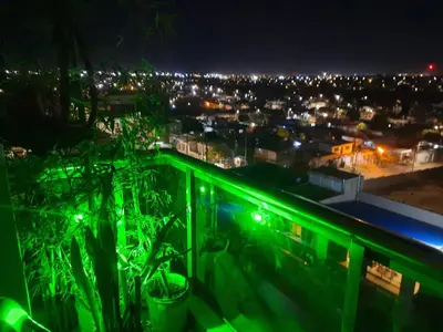a view of a city at night with green lights at Terra Zión in Cordoba