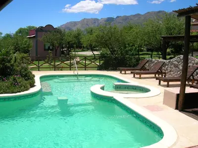 a swimming pool in a yard with chairs and mountains at Apart Los Antiguos in Merlo