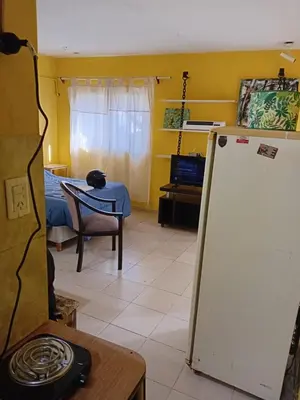 a living room with a refrigerator and a table at Depto Alto Verde in Cordoba