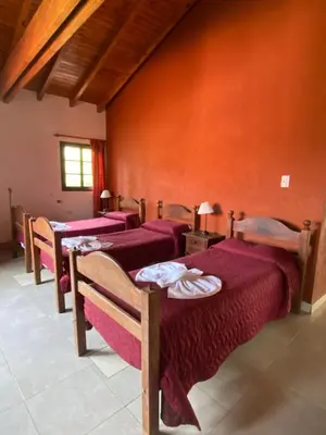 a row of beds in a room with red walls at Posada in Merlo