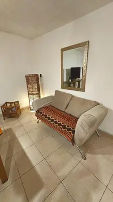 a bedroom with a bed and a mirror on the wall at Temporario Sanatorio Allende Cerro M Suites in Cordoba