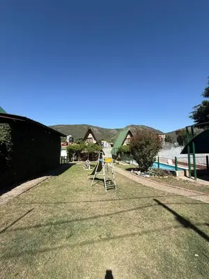 a yard with a ladder on the grass at Cabañas Pindahue - Alojamineto Epehuen in Villa Carlos Paz