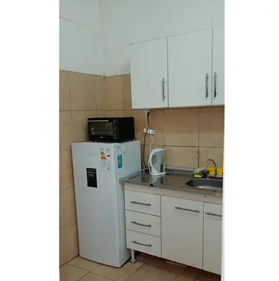 a kitchen with white cabinets and a white refrigerator at El Dpto de Gabicito IV in Cordoba