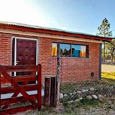 a red brick house with a window and a fence at La Serranita in Panaholma