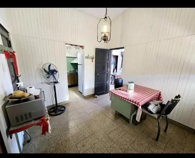 a kitchen with a table and a room with a fan at Cazona Villa Carmen in Villa Carlos Paz