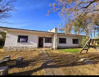 a small white house with a yard at Cazona Villa Carmen2 in Villa Carlos Paz