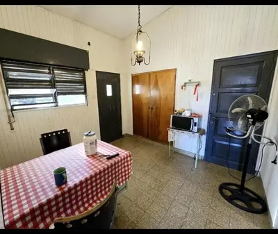 a room with a table and a blue door and a microwave at Cazona Villa Carmen2 in Villa Carlos Paz