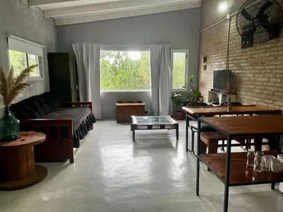 a living room with a couch and a table at Terrazas del Pinar, Loft con pileta exclusiva en bosque serrano in Villa Ciudad de America
