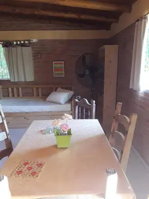 a room with a table and a bedroom with a bed at Casa Sol Y Rio, LOFT MONOAMBIENTE in Mina Clavero