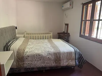 a bedroom with a bed and a window at Cabañas De La Colina in Villa General Belgrano