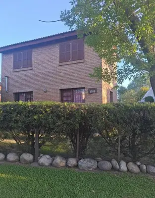 a house with a hedge in front of a building at La casa de Milac in Mina Clavero
