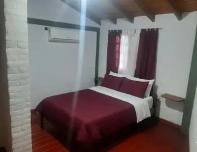 a bedroom with a large bed with a red blanket at La casa de milac in Mina Clavero